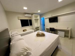 a hospital room with two beds and a desk at Pousada Alphaville in Palmas