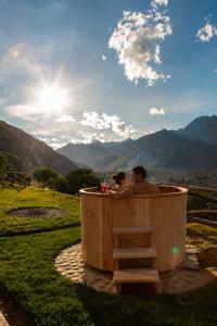 a man and woman sitting in a wooden hot tub at Tara Vegan Lodge - Sacred Valley in Urubamba