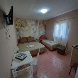 a small room with two beds and a table at Sky 2 Petrovac in Babalonija