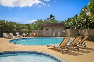 a swimming pool with lounge chairs and a table at Puako Beach Condo 210 - 3 Bedrooms in Waikoloa