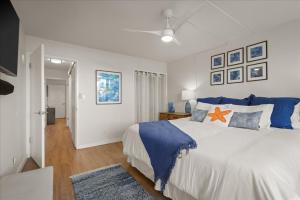 a bedroom with a large bed with blue and orange pillows at Puako Beach Condo 210 - 3 Bedrooms in Waikoloa +19 photos