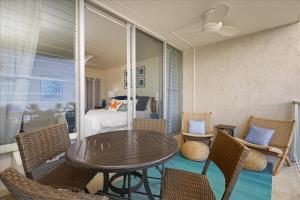 a room with a table and chairs and a bed at Puako Beach Condo 210 - 3 Bedrooms in Waikoloa