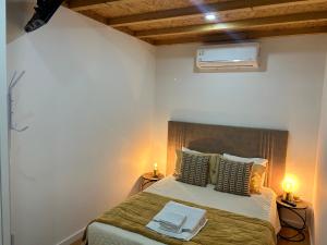a bedroom with a bed with two lamps and a fan at casa de ramalhinha in Caldelas +17 photos