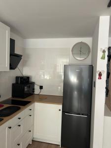 a kitchen with a refrigerator and a clock on the wall at Apartament Drzymały in Lubin