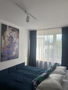 a bedroom with a bed and a painting on the wall at Apartament Drzymały in Lubin