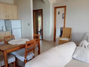 a room with a table and chairs and a kitchen at Ilios in Pogoniá
