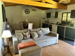 a living room with a couch and a kitchen at casa de ramalhinha in Caldelas