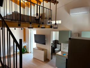 a living room with a television and a staircase at Amarè House in Catania