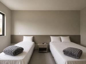two beds sitting next to each other in a room at HOTEL SB Butia in Butiá