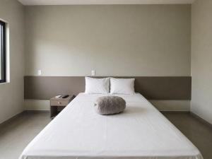 a large white bed with a round pillow on it at HOTEL SB Butia in Butiá +2 photos