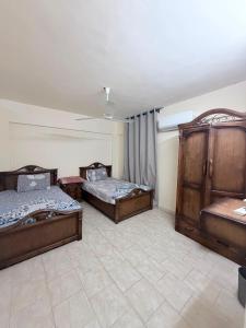 a room with three beds and a ceiling at Marselia Beach 3 in Dawwār Muḩammad Abū Shanab