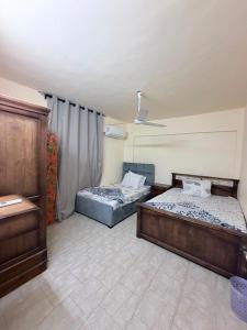 two beds in a room with a ceiling at Marselia Beach 3 in Dawwār Muḩammad Abū Shanab