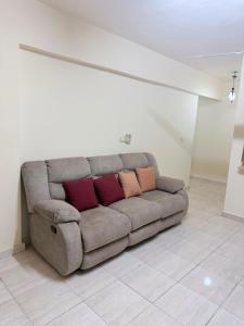 a couch with three pillows sitting in a living room at Marselia Beach 3 in Dawwār Muḩammad Abū Shanab