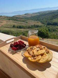 a tray of fruit and a glass of orange juice at Break Room Dea in Draç