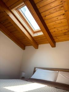 a bedroom with a bed with a wooden ceiling at Amarè House in Catania