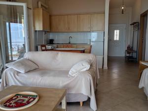 a living room with a white couch and a kitchen at Ilios in Pogoniá +31 photos
