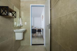 a bathroom with a sink and a toilet and a table at Apartamentos mobiliados em Caruaru in Caruaru +37 photos