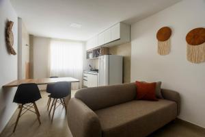 a living room with a couch and a kitchen at Apartamentos mobiliados em Caruaru in Caruaru