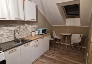 a kitchen with white cabinets and a sink and a table at Windrose in Ustronie Morskie