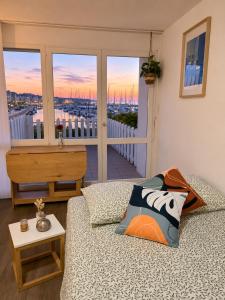 a living room with a couch and a view of a balcony at Escale au Port du Crouesty in Arzon