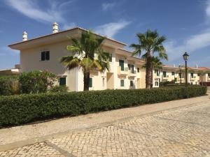 a building with two palm trees in front of it at Quinta Formosa - Villas in Quinta do Lago