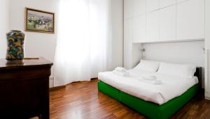 ミラノにあるItalianway-Reggimento Savoiaのベッドルーム1室(ベッド1台、テーブル上の花瓶付)