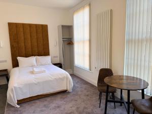 a bedroom with a bed and a table and chairs at Fishergate Residences in Preston