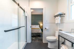 a bathroom with a toilet and a bed at Steveston Cafe & Hotel in Richmond