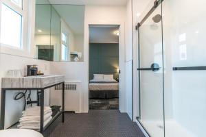a bathroom with a shower and a sink and a bed at Steveston Cafe & Hotel in Richmond
