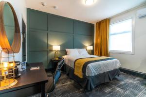 a hotel room with a bed and a desk and a mirror at Steveston Cafe & Hotel in Richmond