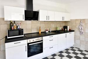 a kitchen with white cabinets and a black counter top at Music Residence in Saarbrücken