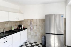 a kitchen with a refrigerator and a checkered floor at Music Residence in Saarbrücken