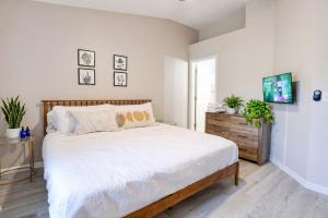 a bedroom with a large bed and a wooden dresser at Stylish Sanctuary King Beds Upscale Condo in Gainesville