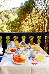 a table with plates of food and drinks on it at Pousada Sonho Verde in Monte Verde