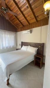 a bedroom with a large white bed with a wooden ceiling at 1Fusion2 in Negril