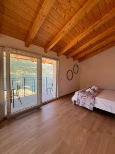 a bedroom with a bed and a balcony at Panoramic and view apartments in Lezzeno