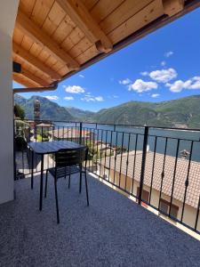 a table on a balcony with a view of the water at Panoramic and view apartments in Lezzeno
