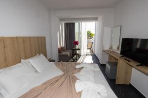 a hotel room with a bed and a television at Hotel Philoxenia in Ammoudia