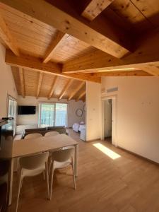 a living room with wooden ceilings and a table and chairs at Panoramic and view apartments in Lezzeno