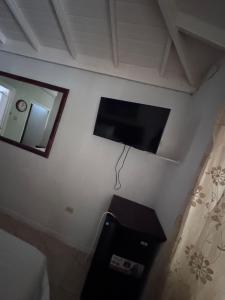 a flat screen tv on the wall of a bedroom at 1Fusion2 in Negril
