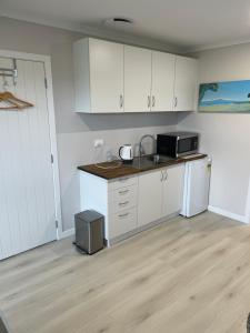 a kitchen with white cabinets and a sink and a refrigerator at # 2 Ald in Cambridge
