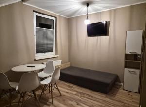 a small room with a bed and a table and chairs at Windrose in Ustronie Morskie +8 photos
