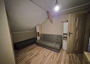 a living room with a couch and a wooden floor at Windrose in Ustronie Morskie
