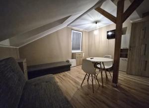 a room with a table and a couch and a table and chairs at Windrose in Ustronie Morskie