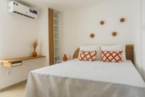 a bedroom with a white bed with two pillows at Apartamentos mobiliados em Caruaru in Caruaru