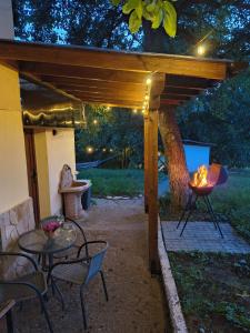 a patio with a fire pit under a wooden pergola at Вила Хармония Harmony Cottage in Kyustendil