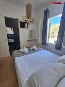 a bedroom with a large bed with towels on it at Sunset Hotel Kini Beachside in Kini