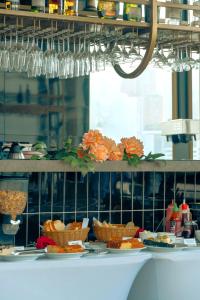 a table with plates of food and baskets of bread at Golden Valley Hotel in Medellín