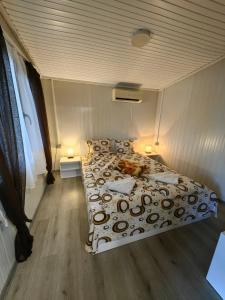 a bed in a small room with two lamps at Къща за гости Зеленец in Sozopol