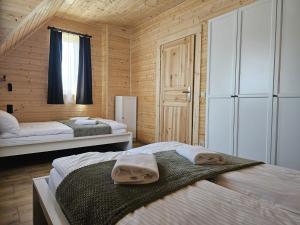 a bedroom with two beds and a window at Tatrzańska Osada 2 - Domki przy stoku narciarskim w Białce Tatrzańskiej in Białka Tatrzańska